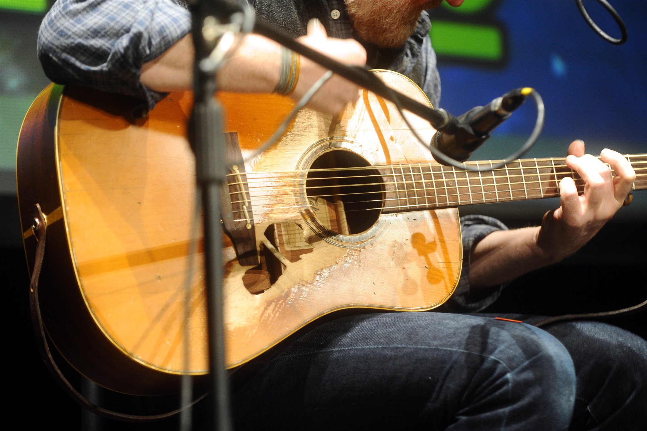 Close-up of Glen Hansard playing his worn acoustic guitar in Lucca in 2015